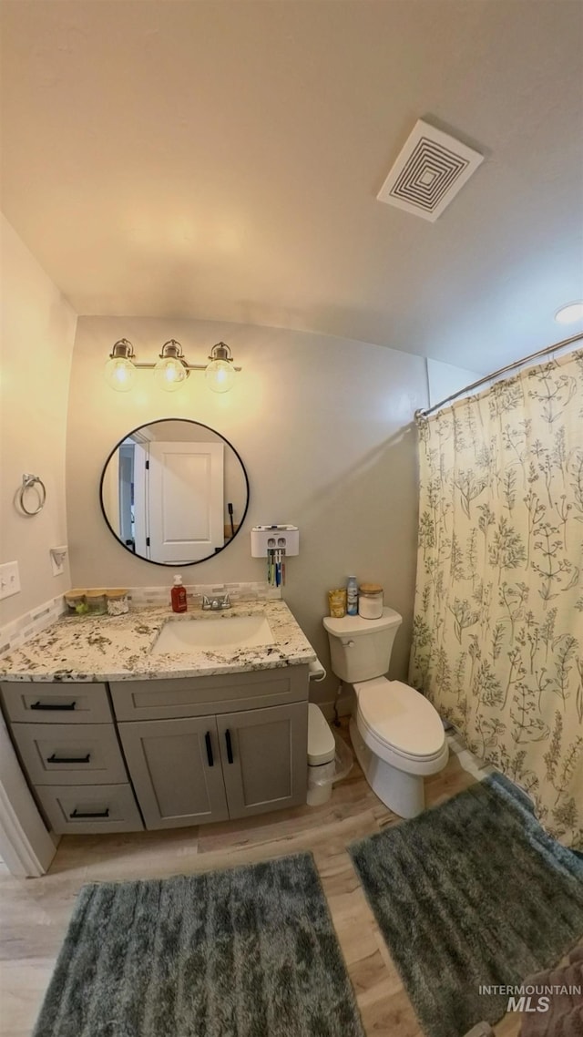 808 Adell Ave, Filer, ID 83328 - full bathroom featuring visible vents, vanity, wood finished floors, toilet, and a shower with shower curtain
