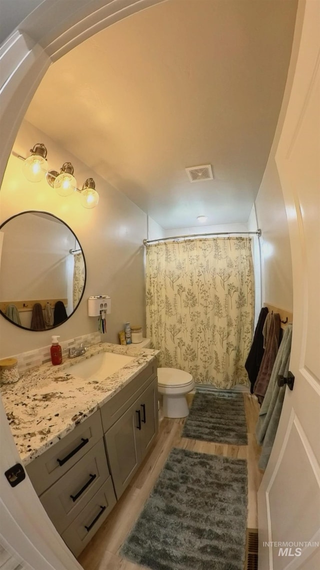 808 Adell Ave, Filer, ID 83328 - full bathroom featuring visible vents, curtained shower, wood finished floors, vanity, and toilet