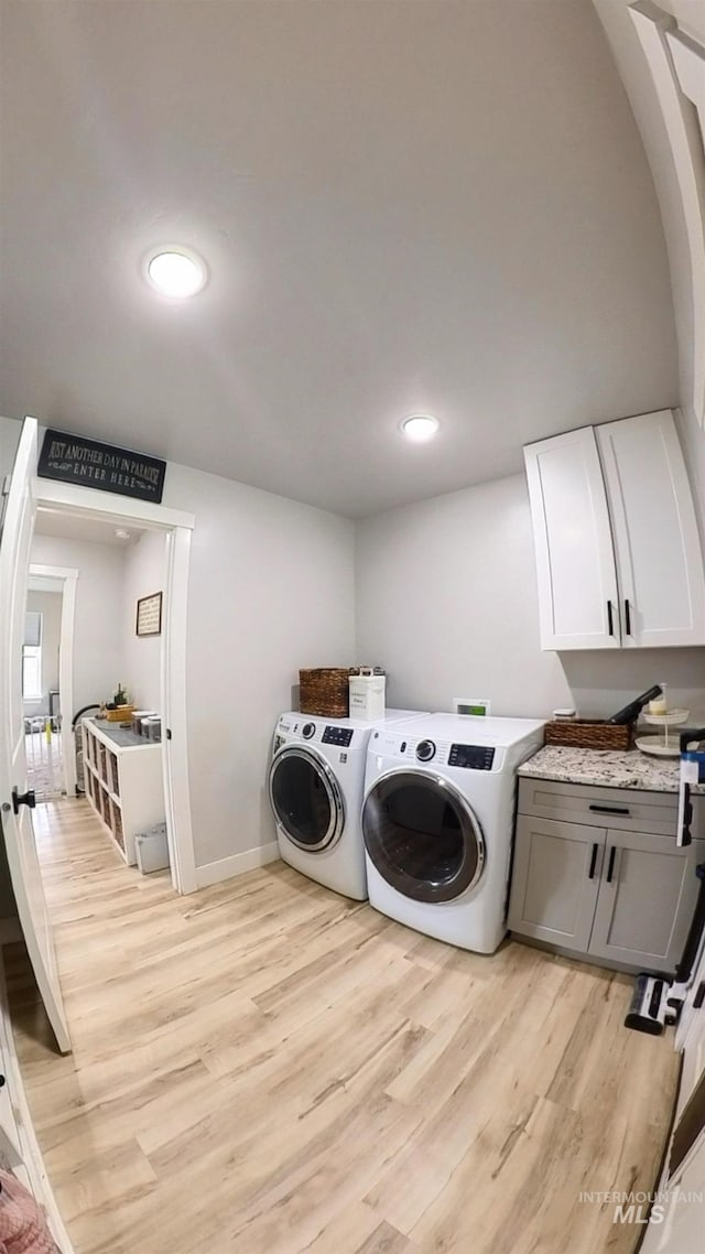 808 Adell Ave, Filer, ID 83328 - clothes washing area featuring cabinet space, baseboards, light wood-style flooring, and washer and dryer