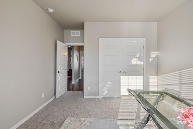 entryway featuring baseboards, carpet floors, and visible vents
