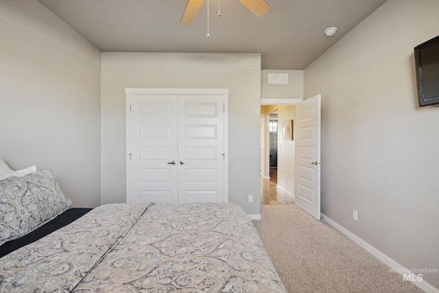 carpeted bedroom featuring a closet, ceiling fan, and baseboards
