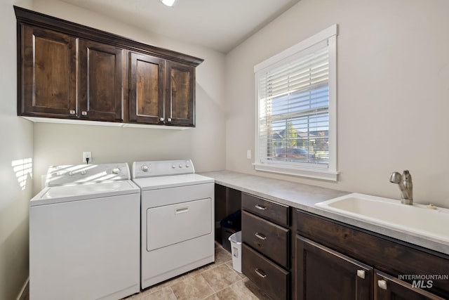 laundry room with washing machine and clothes dryer, cabinet space, and a sink