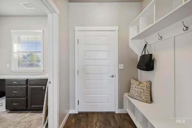 mudroom with wood finished floors, baseboards, and visible vents