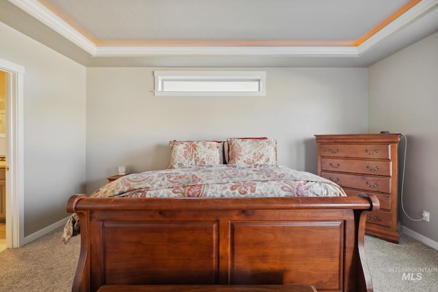 bedroom featuring baseboards, light colored carpet, and a raised ceiling