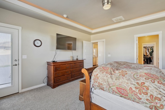carpeted bedroom featuring baseboards, visible vents, and a raised ceiling