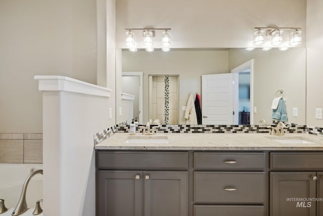 bathroom featuring double vanity, backsplash, and a sink