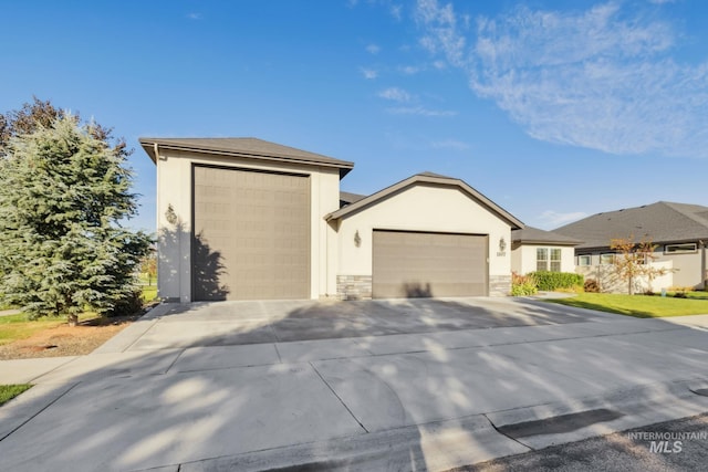 view of front of property featuring driveway, an attached garage, stone siding, and stucco siding