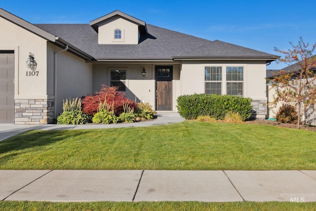 view of front of home with stone siding, an attached garage, a front lawn, roof with shingles, and stucco siding