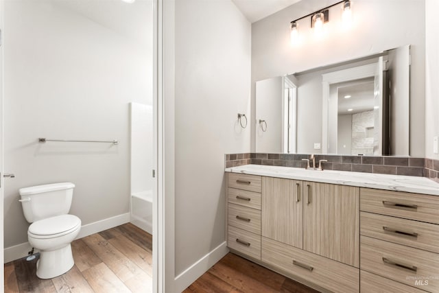 4469 E Wingate Ct, Nampa, ID 83687 - bathroom featuring baseboards, wood finished floors, toilet, vanity, and a bath