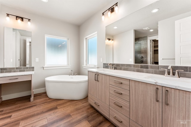 4469 E Wingate Ct, Nampa, ID 83687 - bathroom featuring decorative backsplash, wood finished floors, a soaking tub, double vanity, and recessed lighting