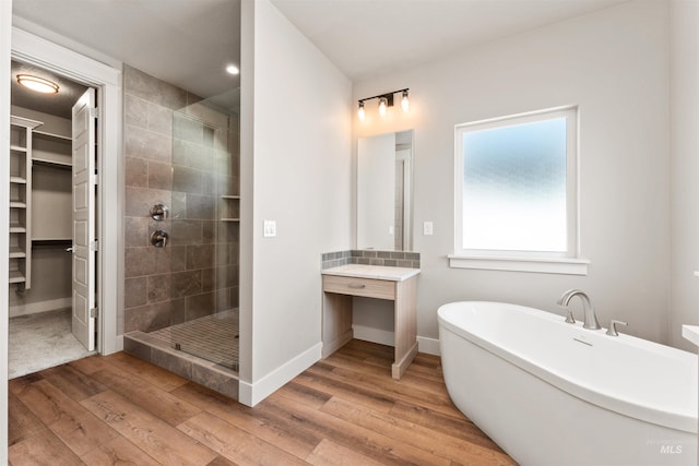4469 E Wingate Ct, Nampa, ID 83687 - bathroom with a stall shower, wood finished floors, baseboards, a freestanding tub, and vanity