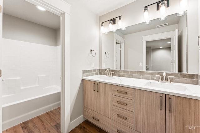 4469 E Wingate Ct, Nampa, ID 83687 - full bathroom with wood finished floors, double vanity, tasteful backsplash, baseboards, and shower / bath combination