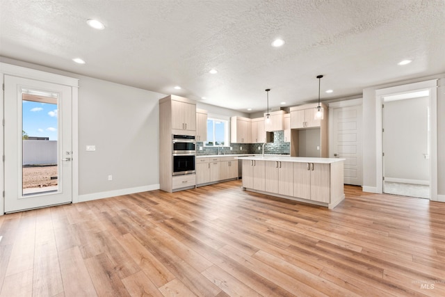 4469 E Wingate Ct, Nampa, ID 83687 - kitchen with stainless steel double oven, recessed lighting, a textured ceiling, light countertops, and light wood-type flooring