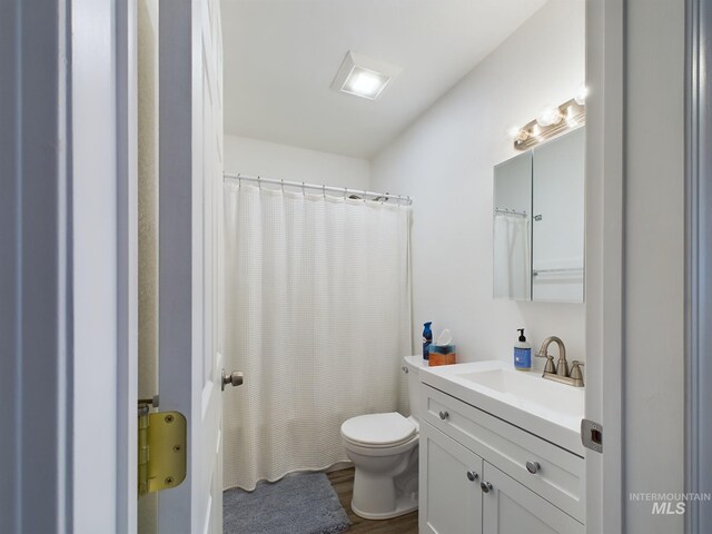 bathroom featuring walk in shower, vanity, toilet, and hardwood / wood-style flooring