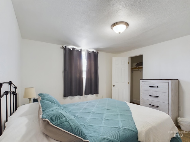 bedroom with a textured ceiling, a closet, and a spacious closet