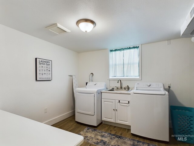 laundry room featuring dark hardwood / wood-style floors, a textured ceiling, sink, and washer and dryer