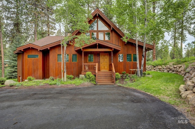 view of front of property featuring roof with shingles and a front lawn