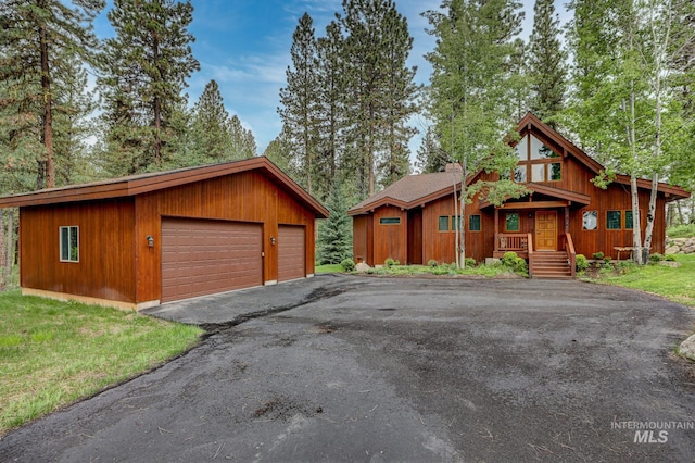 rustic home with a front yard and a detached garage