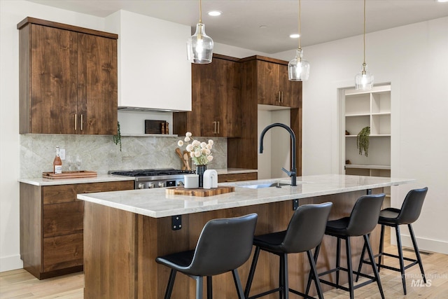 1796 S Eagleson Rd, Boise, ID 83705 - kitchen featuring light wood-style floors, a sink, backsplash, modern cabinets, and an island with sink