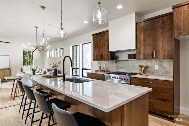 1796 S Eagleson Rd, Boise, ID 83705 - kitchen with stainless steel stove, a sink, light wood-style floors, backsplash, and recessed lighting