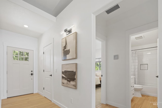 foyer entrance with plenty of natural light, light wood-type flooring, and visible vents