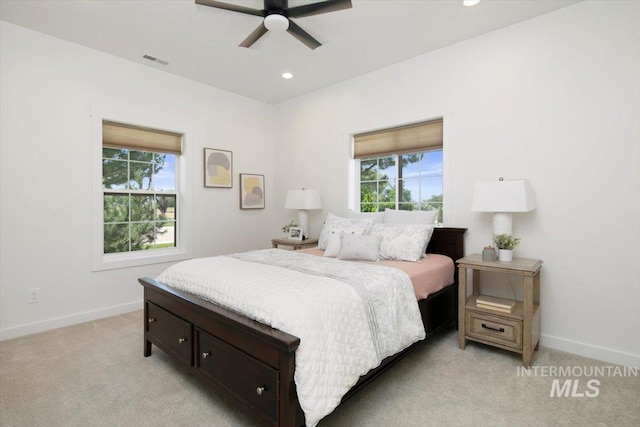 bedroom with light carpet, multiple windows, visible vents, and baseboards