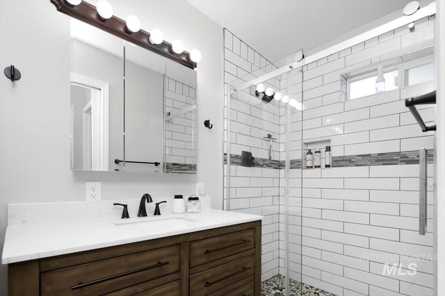 bathroom with a shower stall and vanity