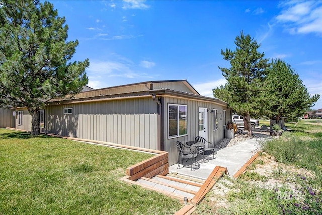 back of property with a lawn and a patio