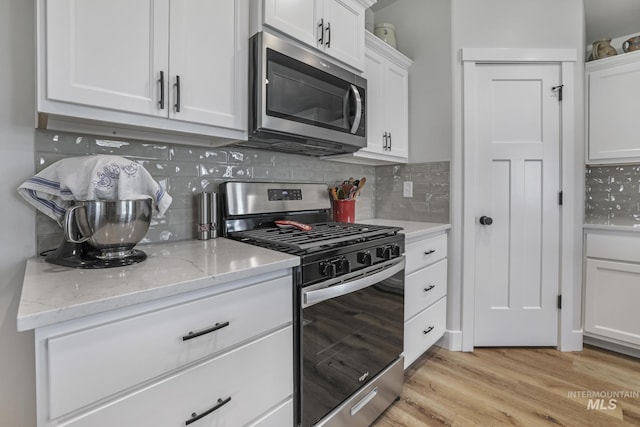 1317 Kyla Ct, Jerome, ID 83338 - kitchen featuring stainless steel appliances, white cabinets, tasteful backsplash, and light wood-type flooring