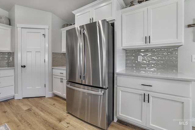 1317 Kyla Ct, Jerome, ID 83338 - kitchen with freestanding refrigerator, decorative backsplash, white cabinetry, light wood-style flooring, and vaulted ceiling