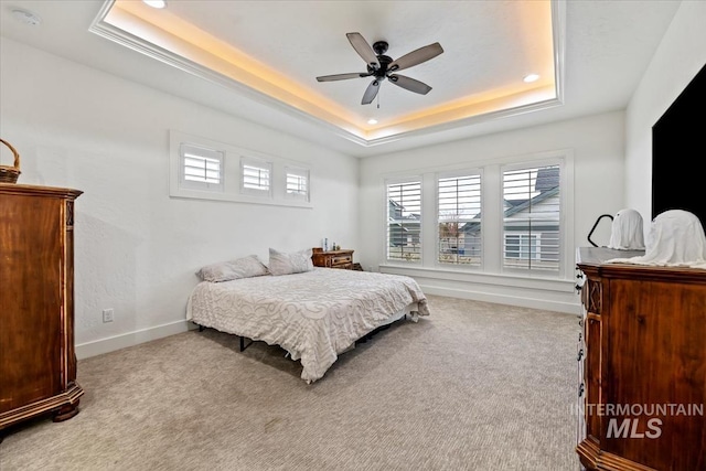 carpeted bedroom with a ceiling fan, baseboards, recessed lighting, and a raised ceiling