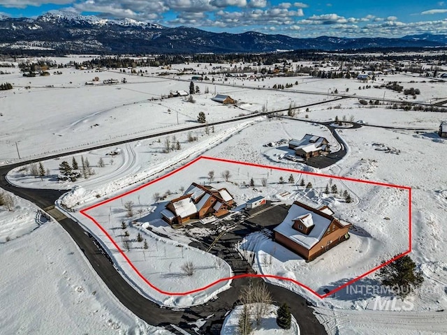 snowy aerial view featuring a mountain view