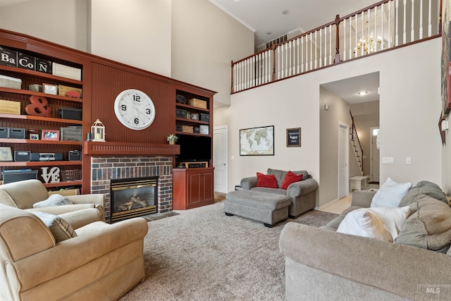 carpeted living area with stairs, ornamental molding, a brick fireplace, and a towering ceiling