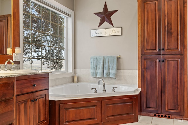 full bathroom featuring a garden tub, vanity, and tile patterned floors