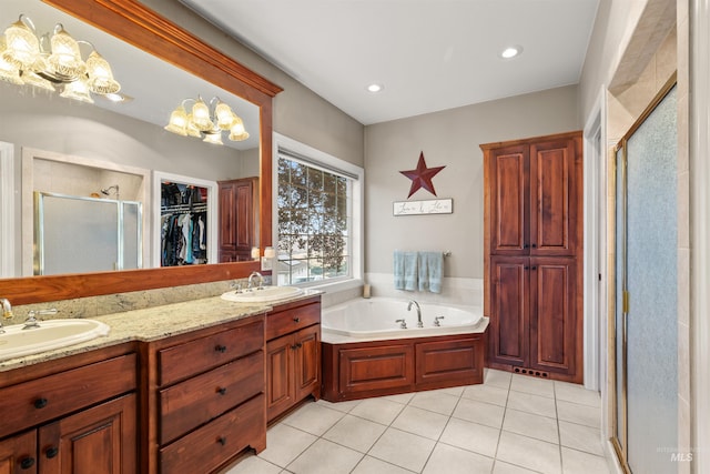 bathroom featuring a stall shower, double vanity, a sink, and tile patterned floors