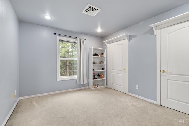 carpeted spare room featuring recessed lighting, visible vents, and baseboards