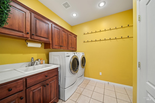 laundry area with light tile patterned floors, cabinet space, visible vents, a sink, and independent washer and dryer