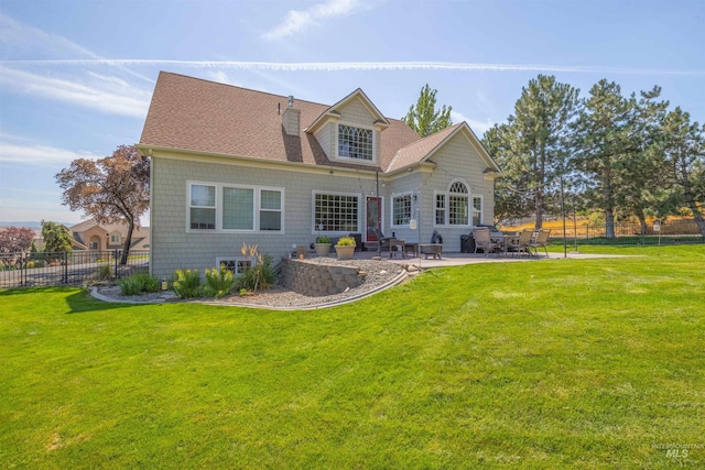 back of house with a yard, a patio area, fence, and roof with shingles