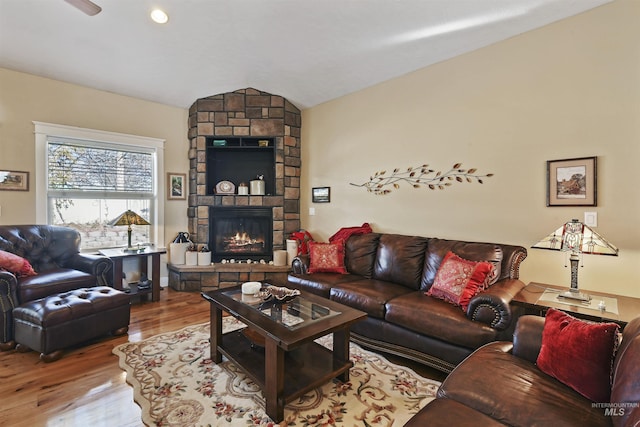 living area with lofted ceiling, a fireplace, and wood finished floors