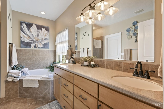 bathroom with tile patterned flooring, a garden tub, a sink, and double vanity