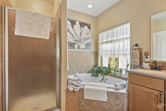 full bathroom featuring a garden tub, a shower stall, and vanity