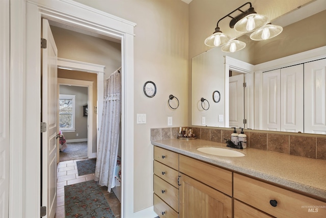 full bathroom with tile patterned floors, baseboards, and vanity