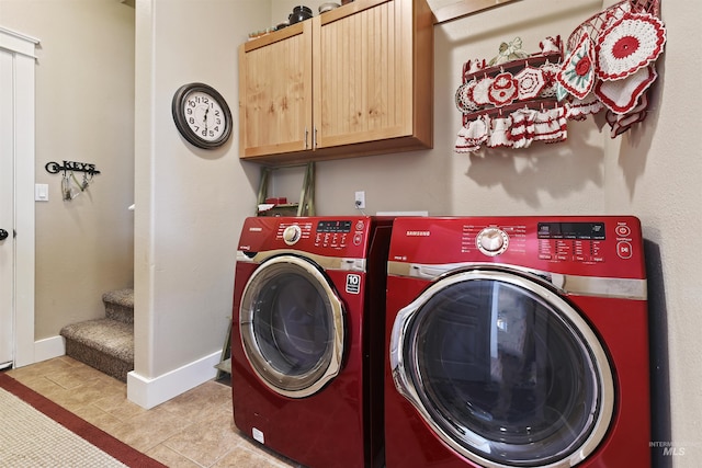 laundry area featuring baseboards, cabinet space, and washing machine and clothes dryer