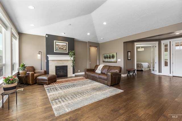 living room with lofted ceiling, a tile fireplace, and hardwood / wood-style flooring