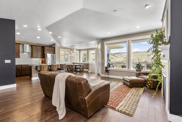 living room with vaulted ceiling, an inviting chandelier, baseboards, dark wood-type flooring, and recessed lighting