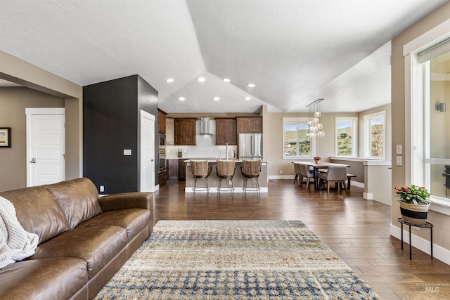 living room featuring recessed lighting, vaulted ceiling, baseboards, and dark wood-style floors