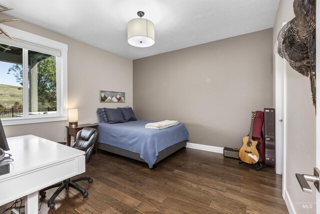 bedroom with baseboards and wood finished floors