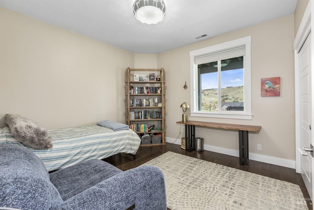 bedroom with baseboards, wood finished floors, and visible vents