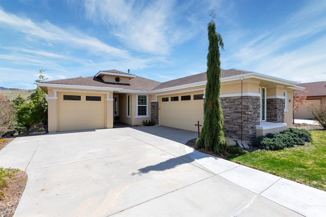 prairie-style house with stucco siding, an attached garage, stone siding, and concrete driveway