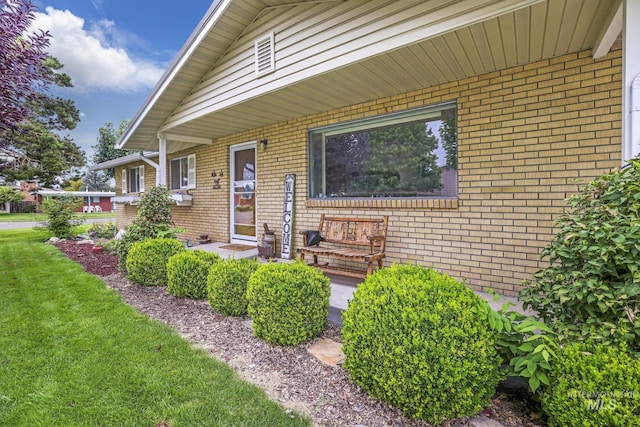 entrance to property featuring a lawn